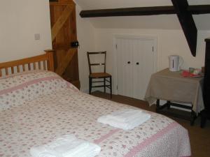 a bedroom with a bed with towels on it at Alltybrain Farm Cottages and Farmhouse B&B in Brecon