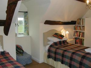 een slaapkamer met een bed en een boekenplank bij Alltybrain Farm Cottages and Farmhouse B&B in Brecon