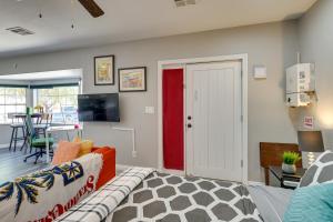 a living room with a red door and a table at Sunny Las Vegas Studio with Shared Pool and Backyard! in Las Vegas