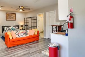 een woonkamer met een oranje bank en een keuken bij Sunny Las Vegas Studio with Shared Pool and Backyard! in Las Vegas