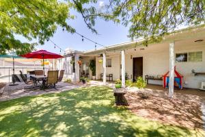 un patio trasero con mesa, sillas y sombrilla en Sunny Las Vegas Studio with Shared Pool and Backyard!, en Las Vegas