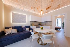 a living room with a blue couch and a table at HelloAPULIA Charming Palazzo Clemente - self-catering suites with aircondition in Monopoli +82 photos