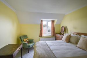 Un dormitorio con una cama, un escritorio y una silla. en Fawley, en Lyme Regis