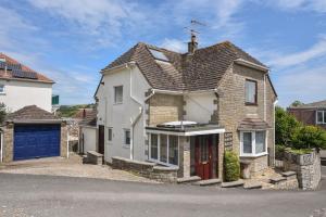 una gran casa blanca con garaje azul en Fawley, en Lyme Regis