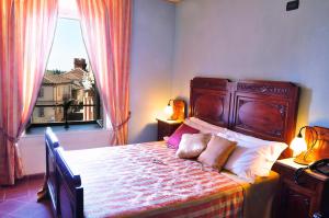 um quarto com uma cama grande e uma janela em La Foresteria del Castello - Wellness Hotel in Dimora Storica em CastellʼAlfero