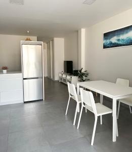 eine Küche mit einem weißen Tisch und einem weißen Kühlschrank in der Unterkunft APARTAMENTOS FREIXO-Rias Baixas in Cangas + 31 Fotos