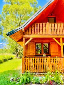 eine kleine Holzhütte mit rotem Dach in der Unterkunft Domek Nida in Polańczyk