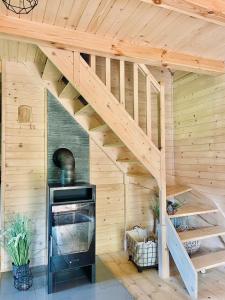 a wooden house with a staircase in a room with a fireplace at Domek Nida in Polańczyk