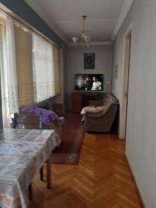 ein Wohnzimmer mit einem Tisch und einem TV in der Unterkunft hotel in chiatura in Chiatʼura