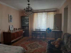 hotel in chiatura في Chiatʼura: غرفة معيشة مع طاولة وغرفة طعام