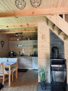 eine Küche mit einem Tisch und einer Holzdecke in der Unterkunft Domek Nida in Polańczyk