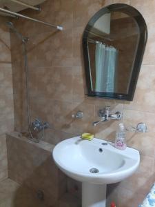 y baño con lavabo blanco y espejo. en hotel in chiatura en Chiatʼura