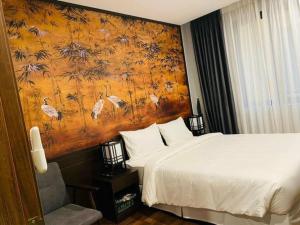 sypialnia z łóżkiem i obrazem na ścianie w obiekcie Wyndham Thanh Thuy Hot Spring MyHome w mieście Phú Thọ