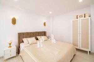 ein weißes Schlafzimmer mit einem großen Bett und einem Schrank in der Unterkunft Palangre Luxury Apartment in Torrevieja