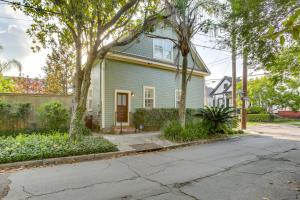 a green house with a tree on a street at Cozy New Orleans Getaway Near Magazine Street! in New Orleans