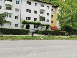 an empty street in front of a white building at La Bloc in Băile Herculane