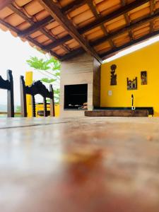een woonkamer met stoelen en een gele muur bij Casa de Temporada em Capitólio - Ternure in Capitólio