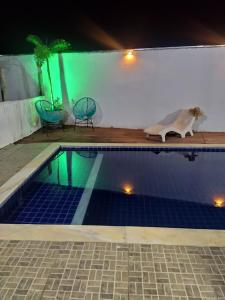 een hond die 's nachts naast een zwembad staat bij Casa de Temporada em Capitólio - Ternure in Capitólio