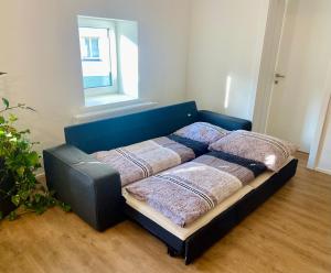 a bed sitting in a room with a window at Ferien-Wohnung für 1-4 Pers in Seenähe in Timelkam