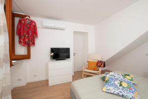 a bedroom with a bed and a tv and a chair at Le Antiche Repubbliche Marinare in Amalfi