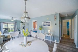 een eetkamer en een woonkamer met een witte tafel en stoelen bij Cocoa Beach Vacation Rental - Walk to Pier! in Cocoa Beach