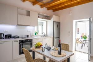 a kitchen with a table with a bottle of wine at Klelia's Apartments in Palekastron