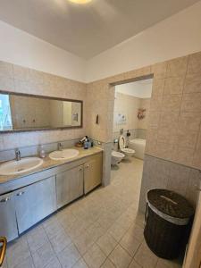 a bathroom with two sinks and a tub and a toilet at Golem Beach Villa in Golem