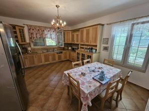 a kitchen with a table with chairs and a refrigerator at Golem Beach Villa in Golem