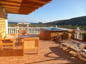 a deck with chairs and a table and a swimming pool at Irini's Guesthouse in Qeparo