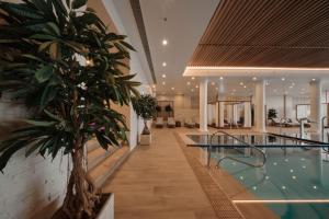 a indoor pool with a palm tree in a building at Praia D'El Rey Marriott Golf & Beach Resort in Casal da Lagoa Seca