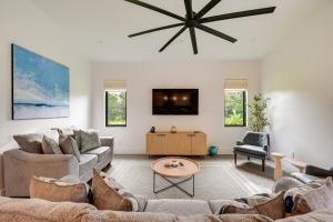 a living room with two couches and a tv at Contemporary Naples Home with Outdoor Kitchen and Pool in Naples