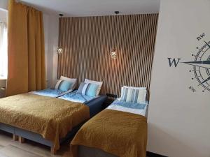een hotelkamer met twee bedden en een klok aan de muur bij Big Blue Apartments nr 6 - 3 osobowy in Władysławowo