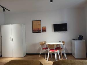 een kamer met een tafel en stoelen en een televisie bij Big Blue Apartments nr 6 - 3 osobowy in Władysławowo