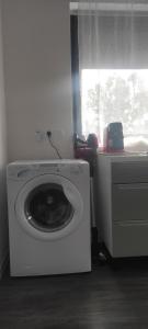 een witte wasmachine in een kamer met een raam bij Grand appartement 2 chambres avec terrasse in Bordeaux