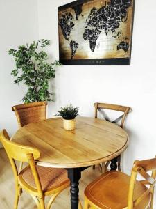 a wooden table with chairs and a world map on the wall at Mademoiselle de Champmeslé in Rouen