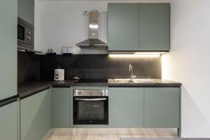 a kitchen with white cabinets and a sink at Lisa Como lake in Gravedona