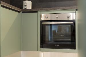 een oven in een keuken met groene kasten bij Lisa Como lake in Gravedona