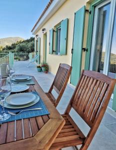 Une table et des chaises en bois sont disponibles sur la terrasse. dans l'établissement Phileo Villas, à Platithriás