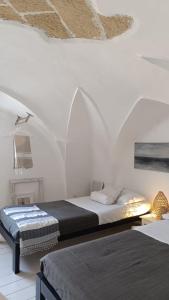 sypialnia z 2 łóżkami w białym pokoju w obiekcie Casa Annina w mieście Gallipoli
