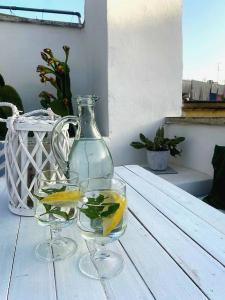 dos copas de vino y un jarrón en una mesa en Casa Annina, en Gallipoli