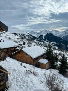 a cabin in the snow with mountains in the background at Charmant Studio 4P Alpe d'huez in LʼHuez