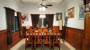 a dining room with a table and a ceiling fan at La maison de Soriya - Work & Stay in Kampot