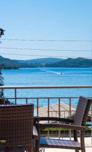 a balcony with two chairs and a view of the water at Nikolaos Apartment 2 in Nydri