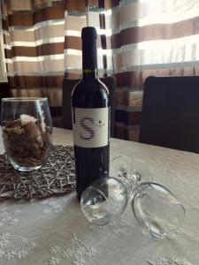 a bottle of wine sitting on a table with glasses at Apartment Niko in Split
