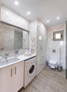 a bathroom with a washing machine and a sink at Nikolaos Apartment 2 in Nydri