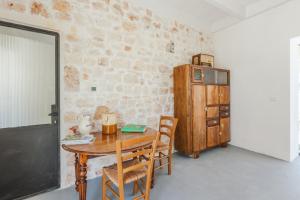 a dining room with a wooden table and chairs at Trulli Meridiem con Piscina in Ostuni
