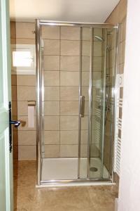 La salle de bains est pourvue d'une douche avec une porte en verre. dans l'établissement Mas Dante, à Cassis