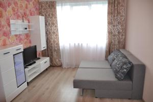 un soggiorno con un divano e una TV di Julia Apartment Riga Imanta a Riga