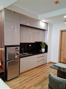 a kitchen with white cabinets and a stainless steel refrigerator at VIVUVIVU77 in Quy Nhon