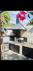 a outdoor kitchen with a stove with a pink flower on it at Villa with pool close to the sea in Saint-Gilles les Bains